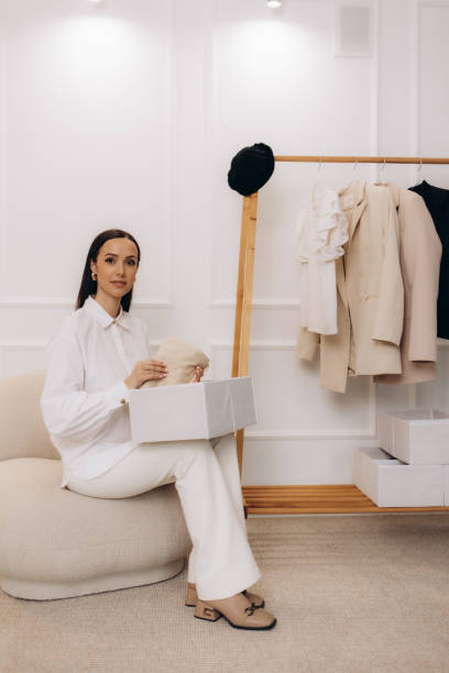 istock Woman putting clean clothes into basket on table 2164745236