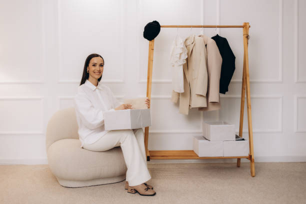 istock Woman putting clean clothes into basket on table 2164745239