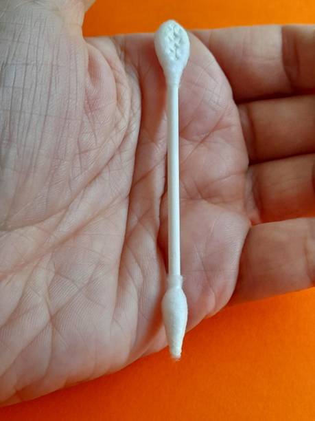 istock Ear cleaning stick in hand with orange background 2164748209