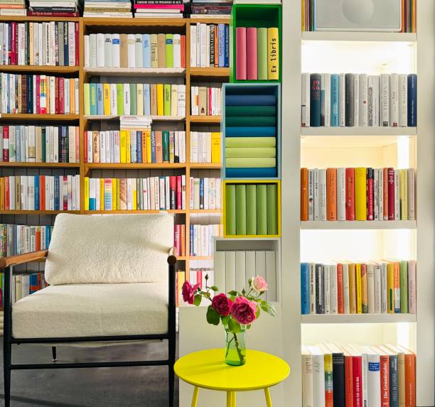 istock Armchair in the illuminated library, square format, in the foreground a roses bouquet on a yellow round table 2164748979