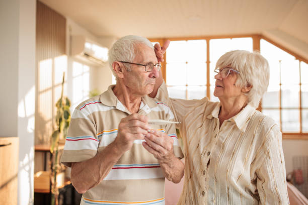 istock Senior couple using a thermometer at home 2164750326