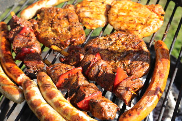 An absolutely delicious assortment of various meats grilling to perfection, including chicken, pork, and tasty sausages