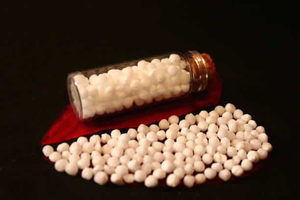 Homoeopathic medicine. Bottles and pills. A close up of glass bottles with homoeopathic pills. Alternative system of medicine. Homoeopathy system of medicine. Half heart is filled with homoeopathic pills. rajkot india stock pictures, royalty-free photos & images