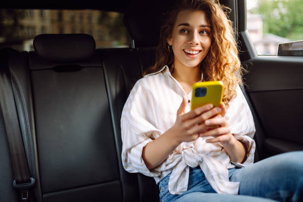 istock Woman with seat belt using phone inside car. 2164752974