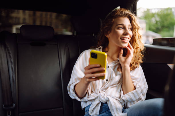 Woman with seat belt using phone inside car.