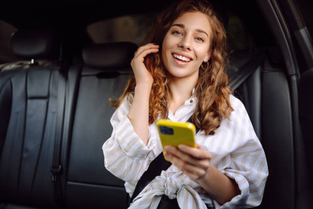 istock Woman with seat belt using phone inside car. 2164752988