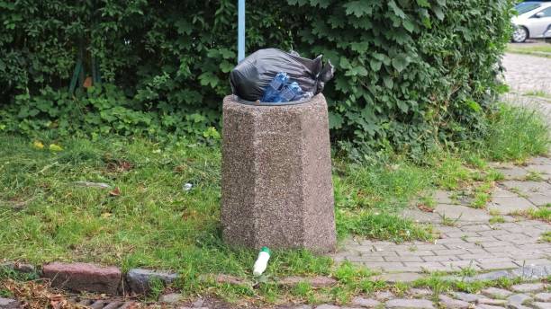 istock Granite Concrete Street Trash Bin Overflowing with Garbage 2164759026