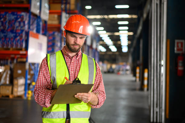 istock Factory workers in safety uniforms inspect and check inventory in workplace warehouse industry logistic export import distribution business concept. 2164760228