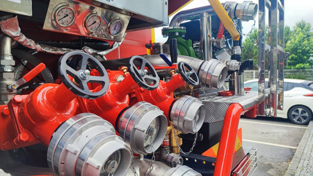 Close up of male hand on control valve in fire engine. Control panel, valves, levers and hoses on fire engine - safety and life saving.