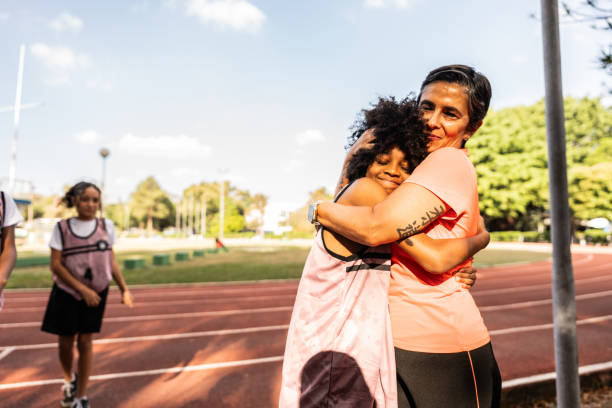 istock Instructor and boy athlete embracing on a running track 2164766850
