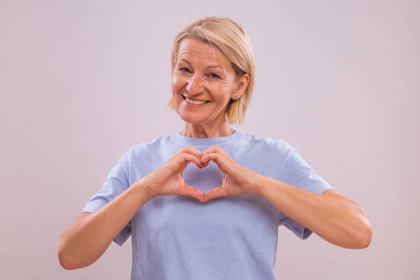 istock Mature woman showing heart shape with hands 2164767411