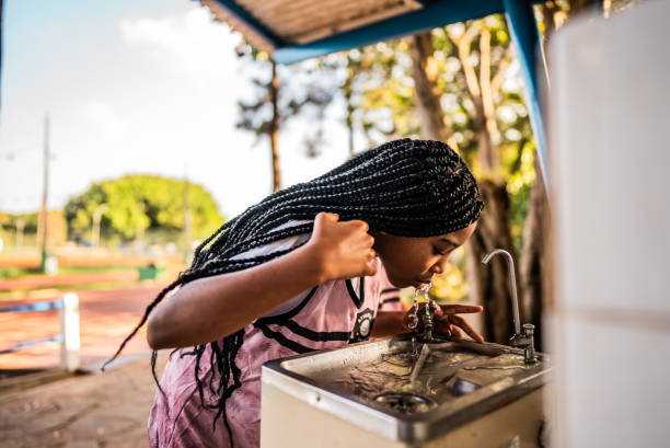 athlete girl drinking water on a running track - pancuran air minum foto potret stok, foto, & gambar bebas royalti
