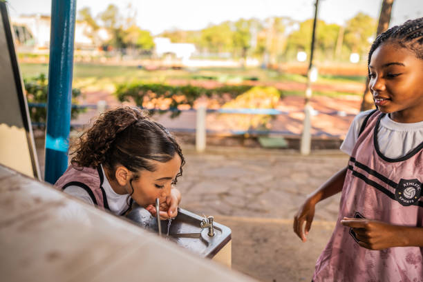 Caucasian girl with water fountain in park on sunny day. Copy space.Horizontal