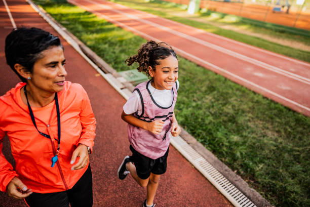 Start. Back to school, kids and education concept. Girl dressed in school uniform as elementary student carrying big backpack before running on treadmill at the stadium or arena. Learning process