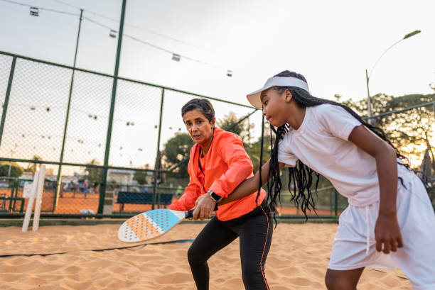 istock Instructor teaching tennis player on a tennis beach venue 2164772598
