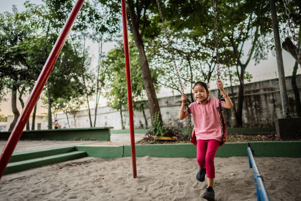 istock Girl playing on swing on a playground 2164772717