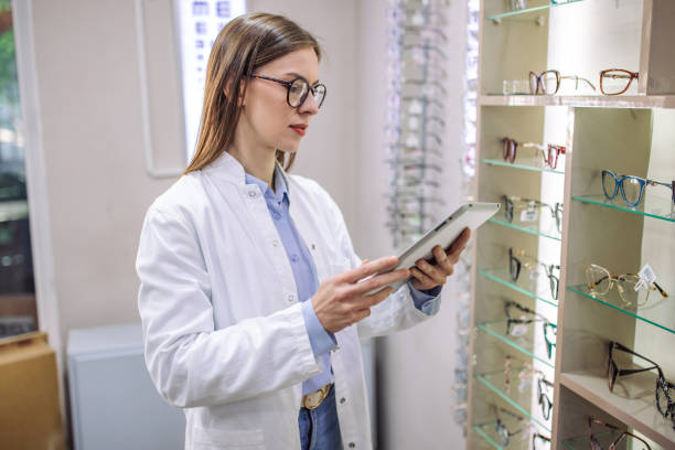 istock Optician using tablet to manage eyewear store inventory. 2164775481