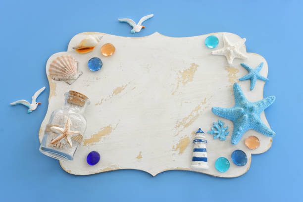 istock Top view image of starfish, shells, sea glass and empty white board over blue background 2164776638