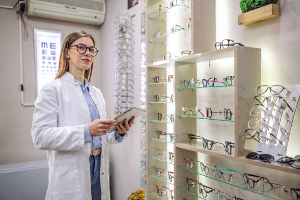istock Optometrist in white coat examining eyeglasses shelf 2164776671
