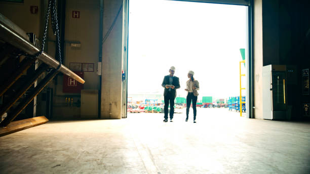 istock Entrepreneurs Discussing while Entering Warehouse Against Sky on Sunny Day 2164777348