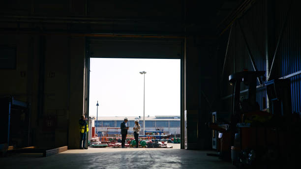 istock Engineers Discussing while Standing at Entrance of Storage Warehouse Against Sky 2164777359
