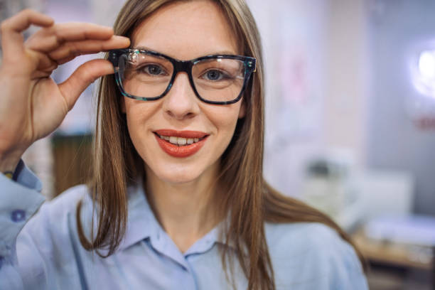istock Person adjusting glasses in a store, selecting frames. 2164777946