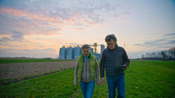 istock Mature Agronomists with Digital Tablet Walking and Discussing in Farm 2164778090