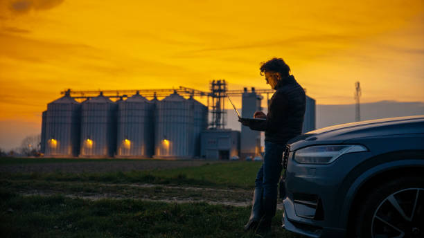 istock Male Agronomist Analyzing Data over Laptop by Car at Organic Farm 2164778111