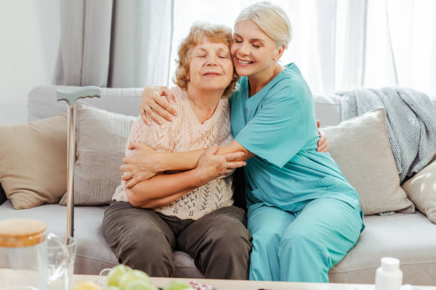 istock Nurse hugging elderly woman on sofa at home 2164778741