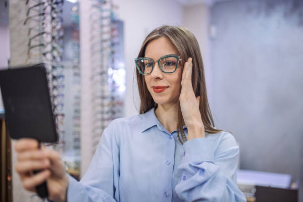 istock Person trying on eyeglasses using a mirror at store. 2164778971