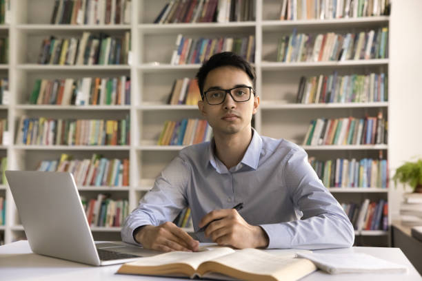 istock Serious Indian male student studying in library 2164781059