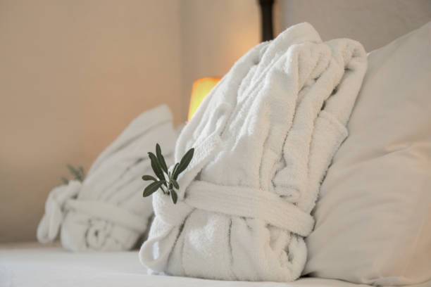 istock Two folded bathrobes on bed in hotel 2164784139