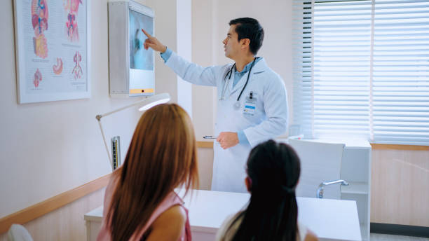 istock Doctor explaining x-ray image to small patient in hospital. 2164784654