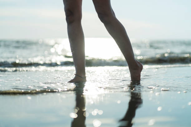 istock Woman enjoys a sunset alone on the beach during her vacation 2164785525