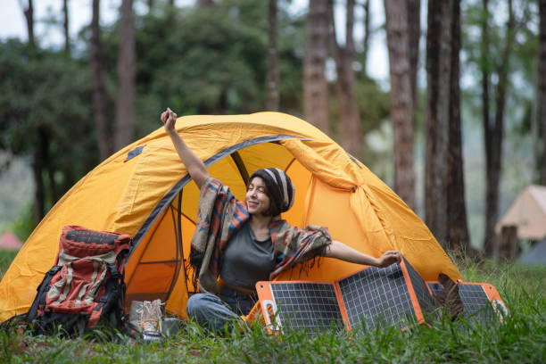 istock Asian female backpacker sitting at tent and doing stretches at camp 2164787194