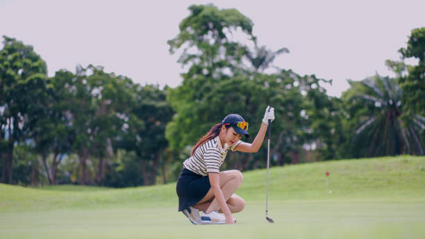 istock Female golf player squatting on green. 2164787255