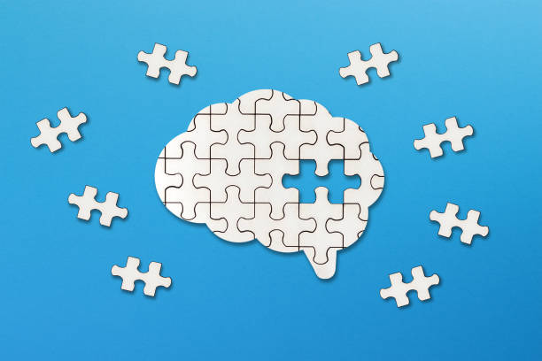 istock Mental health and problems with memory. A missing piece of the brain puzzle. Brain shaped white jigsaw puzzle on blue background. 2164787364