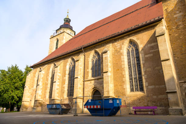 Kirchheim Teck, Baden-Württemberg, Germany, October 18 2023: Martinskirche - Protestant church with construction container and building fence in front of the door, town church from the Middle Ages