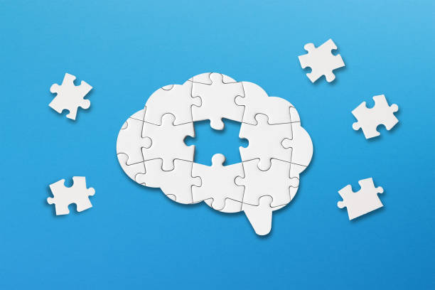 istock Mental health and problems with memory. A missing piece of the brain puzzle. Brain shaped white jigsaw puzzle on blue background. 2164787487