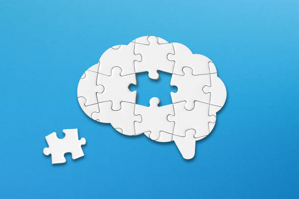 istock Mental health and problems with memory. A missing piece of the brain puzzle. Brain shaped white jigsaw puzzle on blue background. 2164787531
