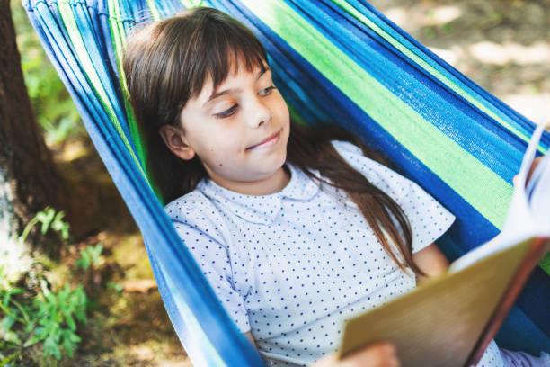 istock Little girl reading interesting book in hammock 2164792499