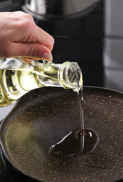 istock Girl Pouring Oil On A Hot Pan, Vertical View 2164792506