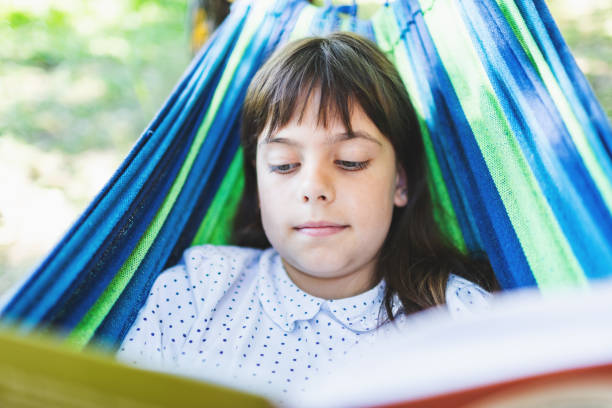 istock Little girl reading interesting book in hammock 2164792532