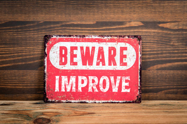 istock Improve. Beware sign with text on a wooden texture office table 2164793581