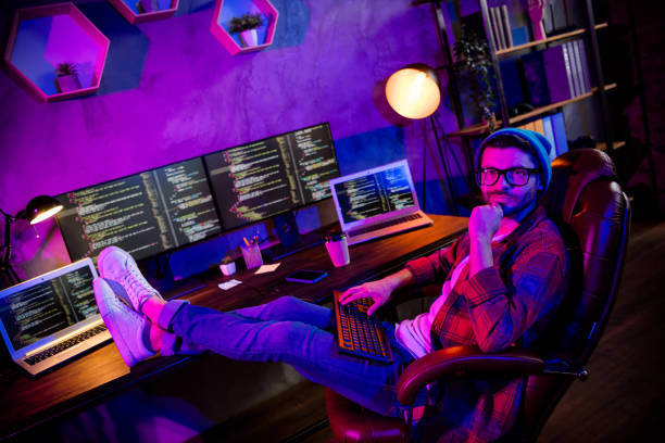istock Photo of thoughtful minded coder dressed hat eyewear creating safety system indoors workplace workstation loft 2164794430