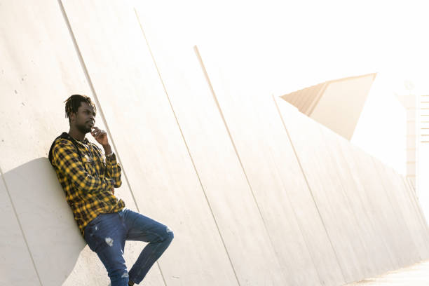 istock black man leaning against a concrete wall 2164798471