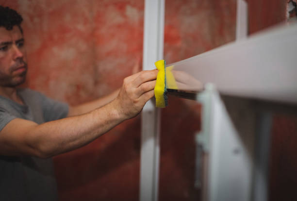 istock Caucasian male builder washes window frames with a sponge. 2164798652