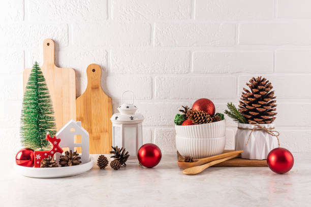 istock Home Countertop Kitchen Christmas decorations, balls, a mini Christmas tree, a lantern, a cones in a bowl, large cedar cone in a planter. Front view. 2164801124