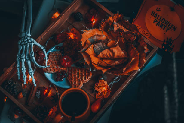 Wooden tray with breakfast and hand skeleton on the bedside table.