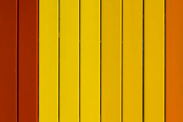 Close-up taken of Freshly painted wooden fence or wall in yellow and brown tones
